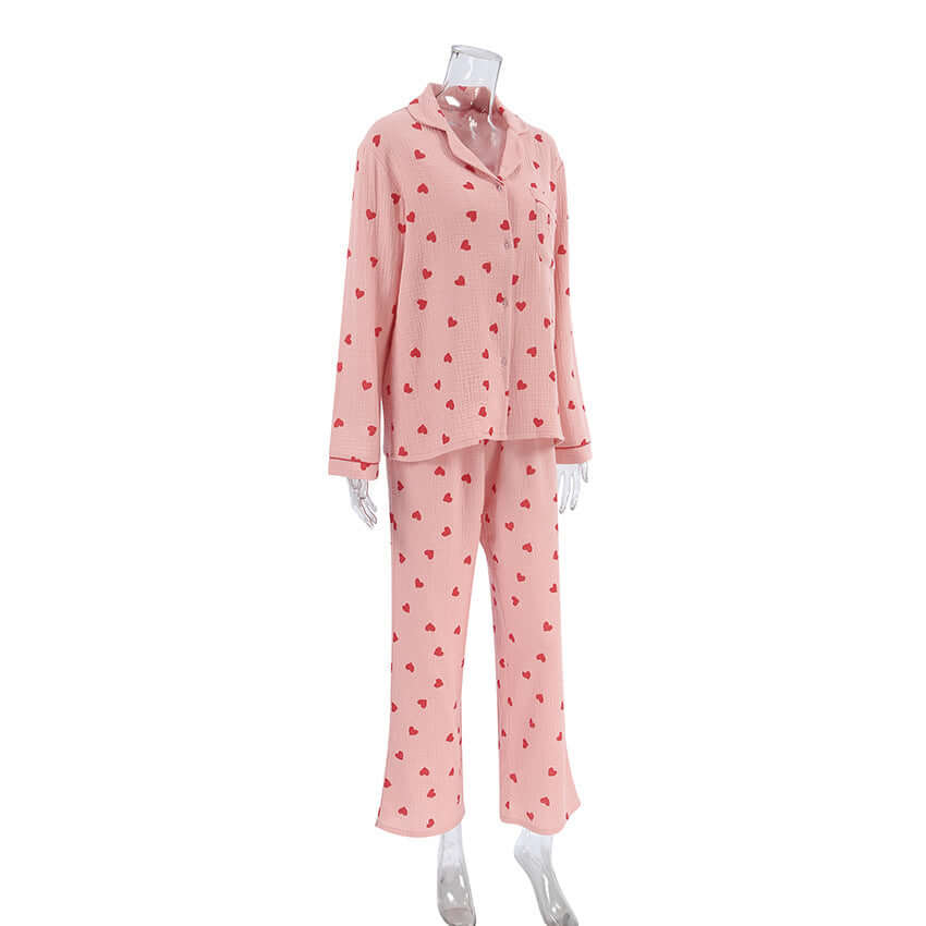 Soft pink cotton pajamas suit with heart prints, featuring long sleeves and trousers. Ideal for comfortable sleepwear.