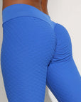 Seamless blue nylon moisture-wicking sports leggings with textured design, perfect for yoga and fitness activities.