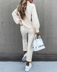 Casual high neck long sleeve pocket trousers two-piece suit in beige, paired with a white handbag and sneakers.