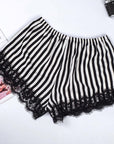 Pink and black and white striped satin pajama shorts with lace trim, perfect for summer home wear.