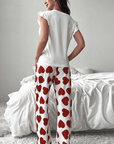 Back view of a woman wearing a red heart print pants lounge set with a ruffled white tank top.