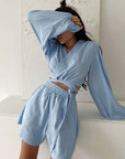 Young woman in light blue two-piece cotton pajamas, styled for casual outdoor and home wear.