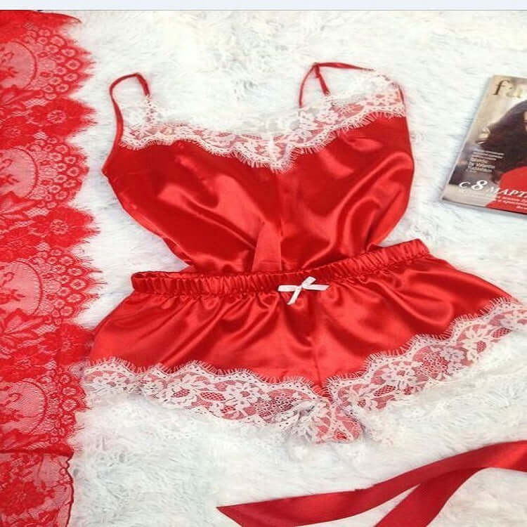 Red lace-trimmed satin women&#39;s pajamas set flat lay on a soft background, showcasing elegant sleepwear.