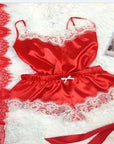 Red lace-trimmed satin women's pajamas set flat lay on a soft background, showcasing elegant sleepwear.