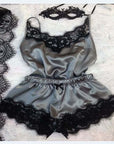 Elegant women's satin pajamas set with black lace trim and matching mask for a chic bedtime look.