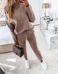 Casual high neck long sleeve two-piece suit in beige with pockets, styled with white sneakers and a chic handbag.