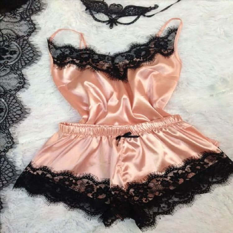 Elegant pink ice silk women&#39;s pajamas with black lace trim, perfect for stylish loungewear.