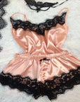 Elegant pink ice silk women's pajamas with black lace trim, perfect for stylish loungewear.