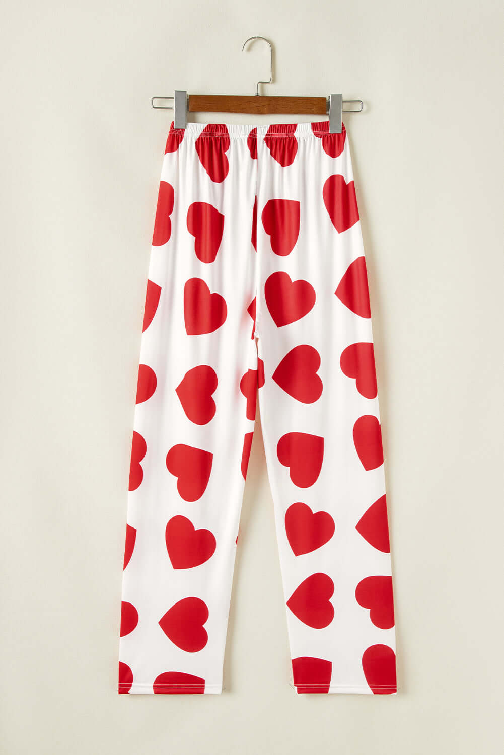 White lounge pants with red heart prints, part of a women&#39;s pajama set for a stylish and cozy look.