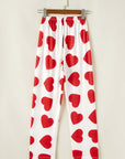 White lounge pants with red heart prints, part of a women's pajama set for a stylish and cozy look.