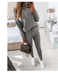 Casual high neck long sleeve two-piece suit in grey with pocket trousers and white sneakers.