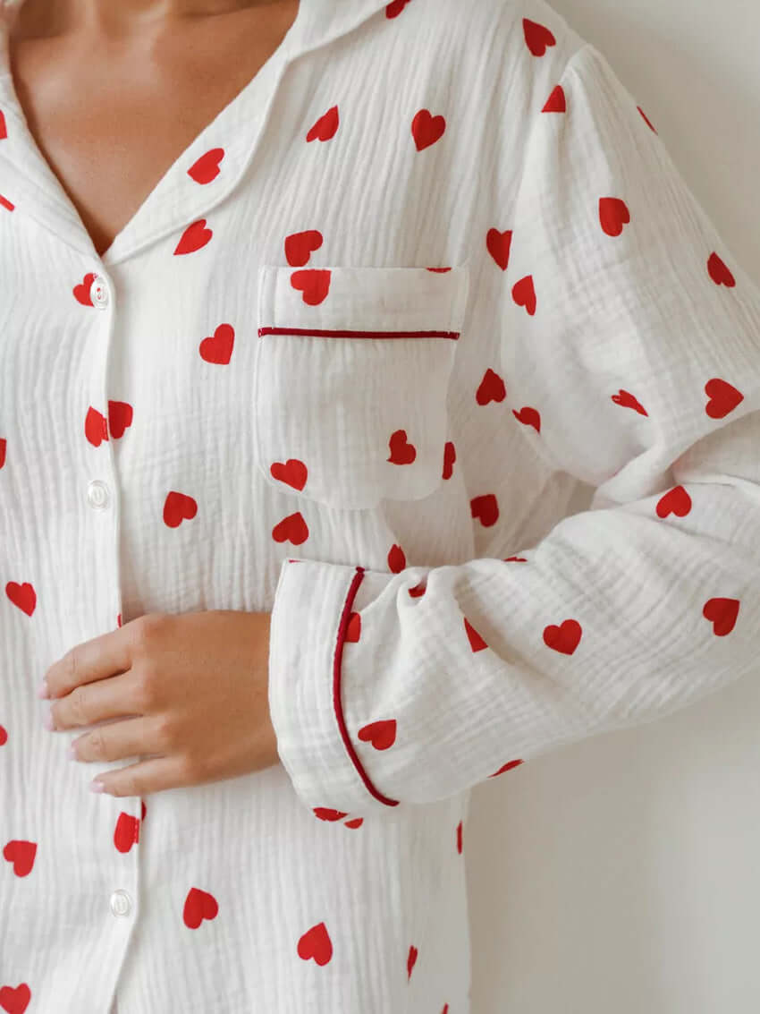 White cotton pajamas with red heart print and long sleeves, perfect for comfortable sleepwear.