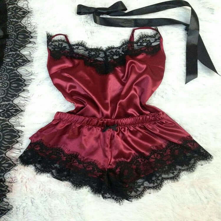 Burgundy satin women&#39;s pajama set with lace trim featuring a tank top and shorts.