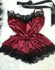 Burgundy satin women's pajama set with lace trim featuring a tank top and shorts.