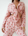 Comfortable pink cotton pajamas set with heart print, featuring long sleeves and tied crop top.