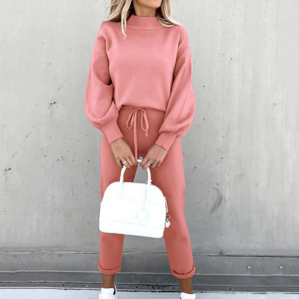 High neck long sleeve casual pink two-piece suit with pockets and white handbag, perfect for relaxed outings.