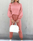 High neck long sleeve casual pink two-piece suit with pockets and white handbag, perfect for relaxed outings.